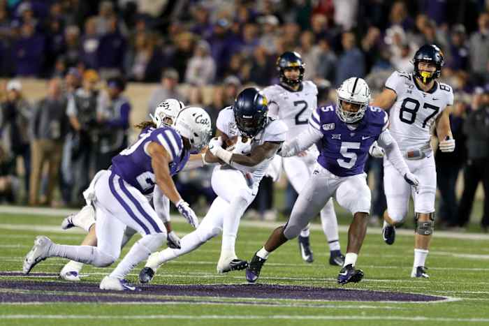 West Virginia Mountaineers running back Leddie Brown (4) is tackled by Kansas State Wildcats linebacker Da'Quan Patton (5) and defensive back Denzel Goolsby (20) during the fourth quarter of a game at Bill Snyder Family Stadium